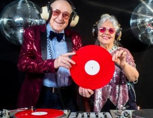 an amazing grandma and grandpa, older couple djing and partying in a disco setting