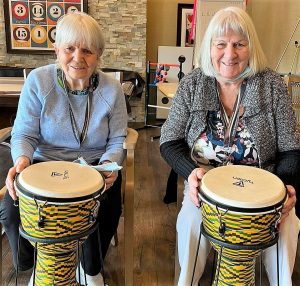 Two senior women playing drums