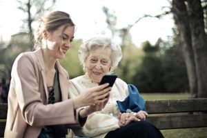 young woman explains how to use smartphone to elderly woman