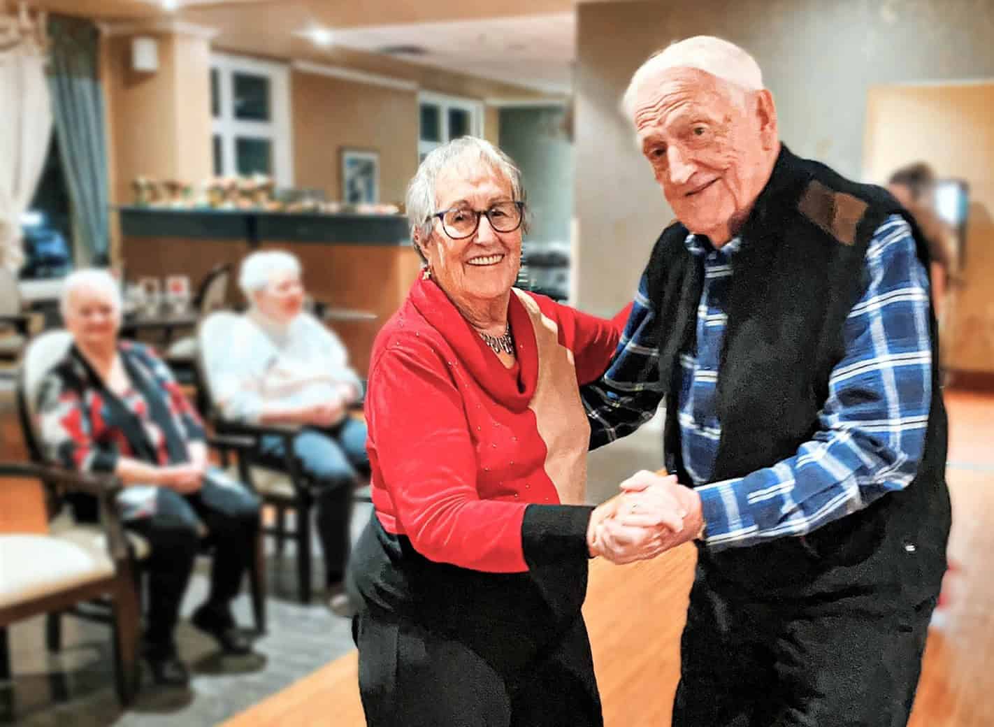 Senior couple dancing and smiling.