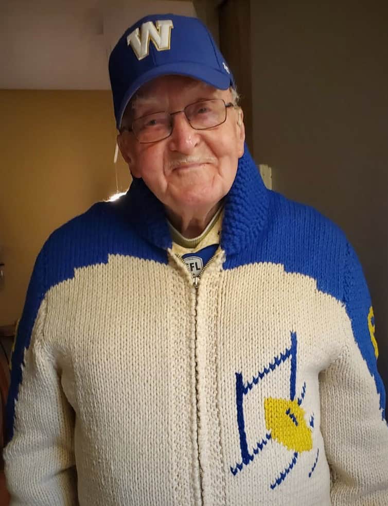 Head-To-Head: Which Retirement Residence Has the Grey Cup Edge? - All Seniors Care Smiling senior man over 100 years old in Winnipeg Blue Bombers sweater.