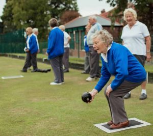 Senior women in blue sweaters playing bocce ball